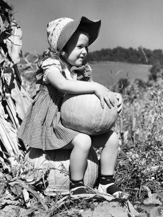 Girl Sitting on Pumpkin, Wearing Sun Bonnet